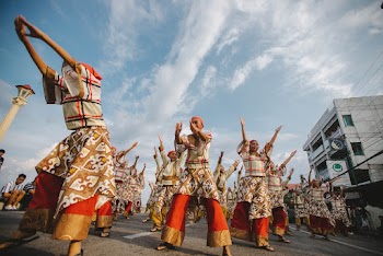 People in Gold and Red Traditional Dress Dancing on the Street