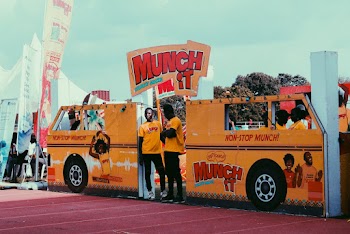People In Uniform Yellow T-shirt Inside A Brightly Painted Stall Shaped Like A Bus