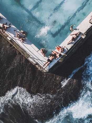 people lying on side of pool
