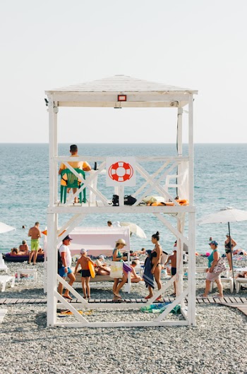 People Near Beach With Lifeguard Gazebo