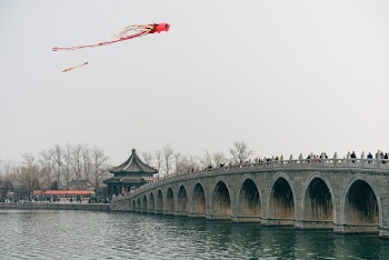People On A Bridge Watching Kites Fly 
