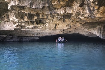 People on Boat Under Cave