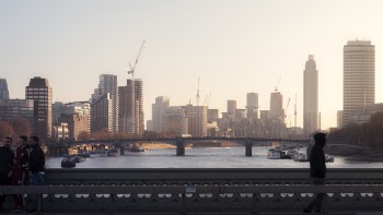 People on Bridge With Background of City