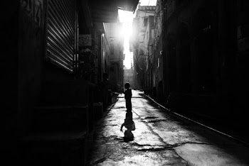 People on Empty Street Between Buildings