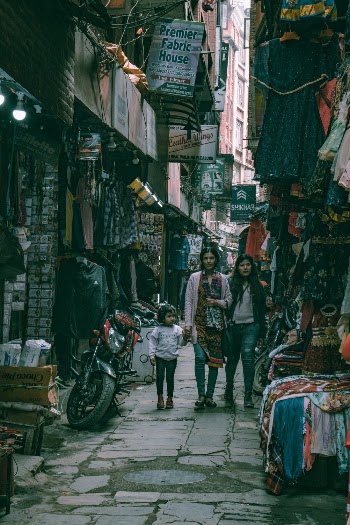 People on Pathway Between Stores