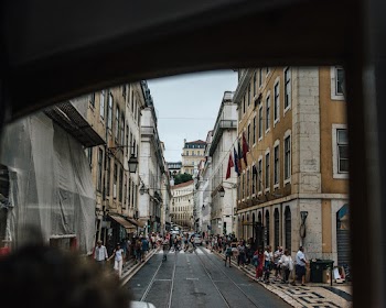 People on Road Between Buildings