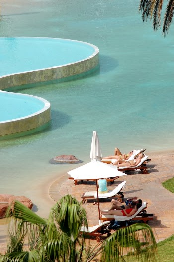 People on Sun Loungers on a Tropical Beach