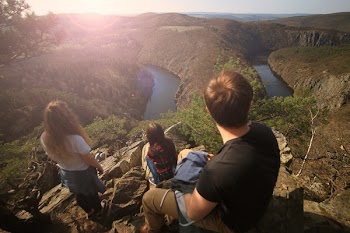 People on Top of Cliff With Water at the Bottom during Daytime