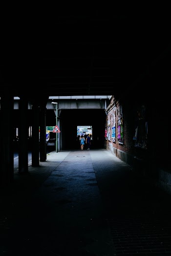 People Passing By at the Dark Tunnel