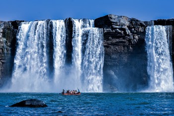 People Riding Boat Near Waterfall