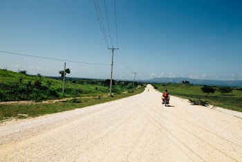 People Riding Motorcycle on Road Viewing Green Field