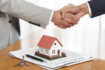 People shaking hands and toy model background Free Photo