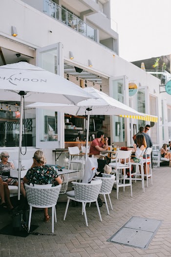 People Sitting and Standing on Patio Sets