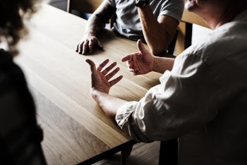 People Sitting in Front of Wooden Table