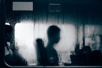 people sitting on other side of moistened window