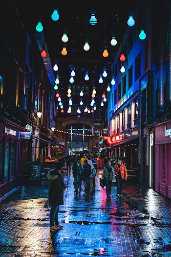 People Standing Between Buildings during Nighttime