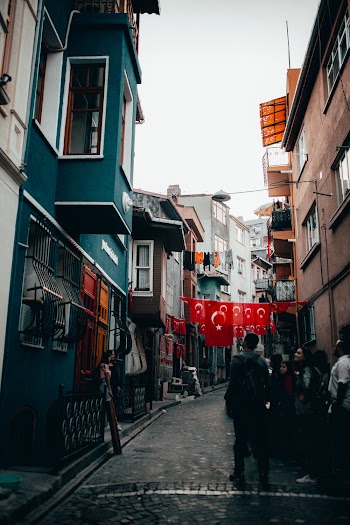 People Standing In Front Of A Building In A Narrow Street