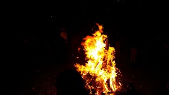 People Standing in Front of Fire