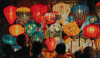 People Standing Near Assorted-color Lamps