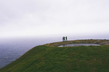 People Standing Near Body Of Water