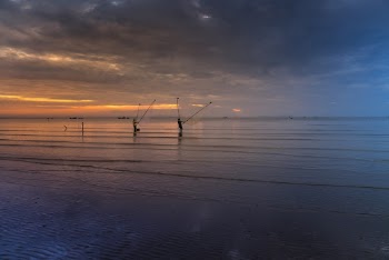 People Standing on Ocean Holding Fish Nets