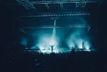 People Standing On Stage In Front Of Crowd