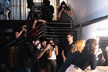 People Taking Photo of Women in Front of Mirror