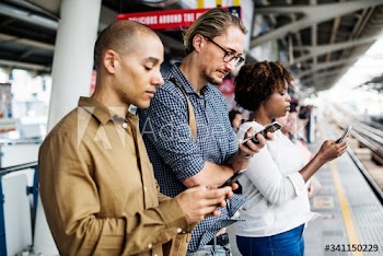 People using smartphones on a train platform