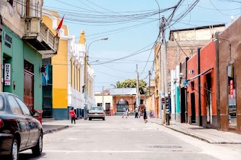 people waking in road between concrete buildings