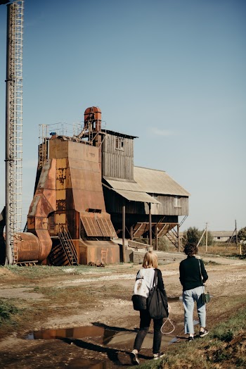 People Walking Across Brown and Gray Factory Building