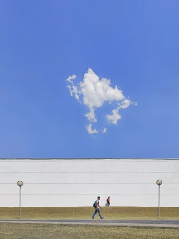 People Walking Beside A High Wall