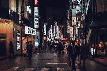 people walking beside building during nighttime