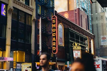 people walking beside high buildings during daytime