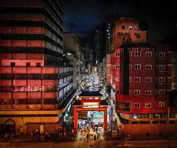 people walking between buildings at night