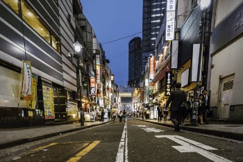 People Walking Between High-rise Buildings