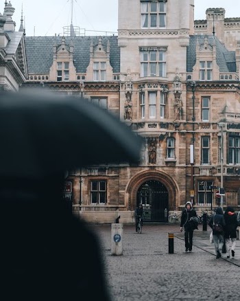 people walking in front of brown concrete building