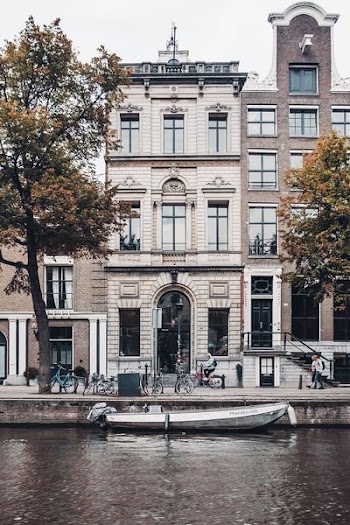 people walking in front of white building