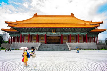 People Walking Near Yellow and Gray Temple