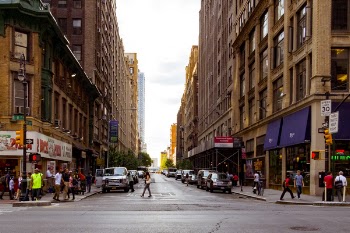 People Walking on Alley Surrounded by High Rise Buildings