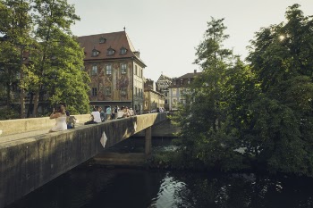 People Walking on Bridge Near the Town during Daytime