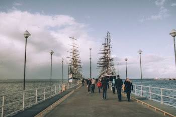 People Walking on Bridge Under Gray