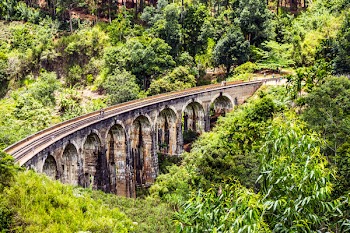 People Walking on Bridge With Railroad during Day
