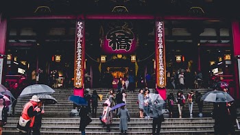 people walking on concrete stairs in front of temple