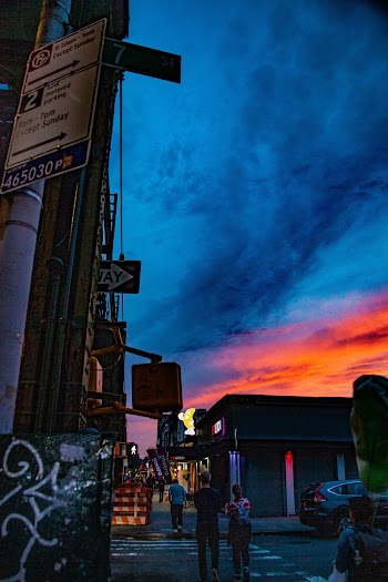 People Walking Under Blue and Red Sky