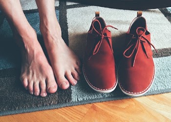 Person's Feet Beside Brown Shoes