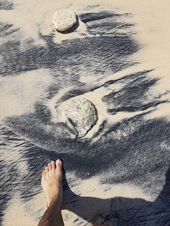 Person's Foot on Sand Near Rock