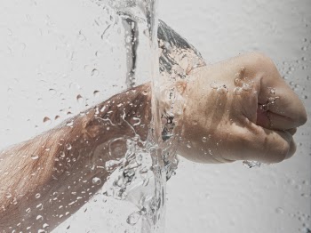 Person's Left Fist Punching Water