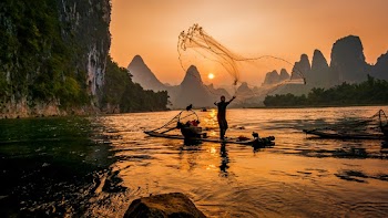 Person's on Boat Throwing Fishing Net