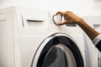Person Adjusting Control on Front-load Clothes Washer
