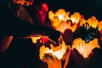 person burning paper on lighted candles